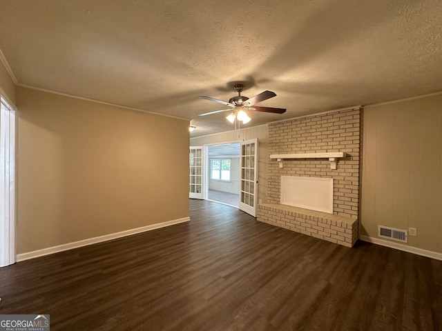 unfurnished living room featuring ceiling fan, a textured ceiling, dark hardwood / wood-style flooring, and ornamental molding