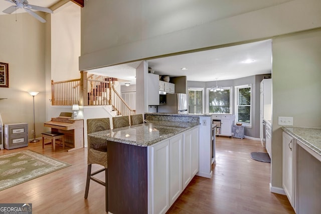 14 Rivendell Way, Hayesville, NC 28904 - kitchen featuring freestanding refrigerator, a breakfast bar, light wood finished floors, white cabinets, and recessed lighting