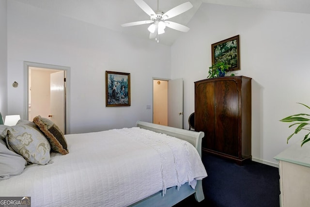 bedroom with dark colored carpet, ceiling fan, high vaulted ceiling, and connected bathroom