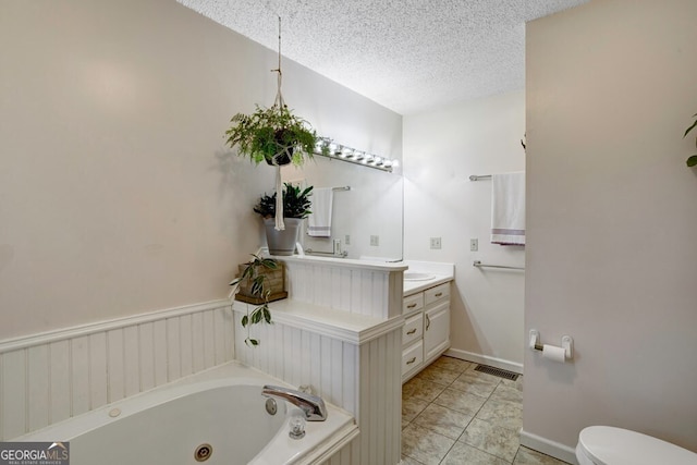 bathroom featuring a bathtub, tile patterned floors, vanity, a textured ceiling, and toilet