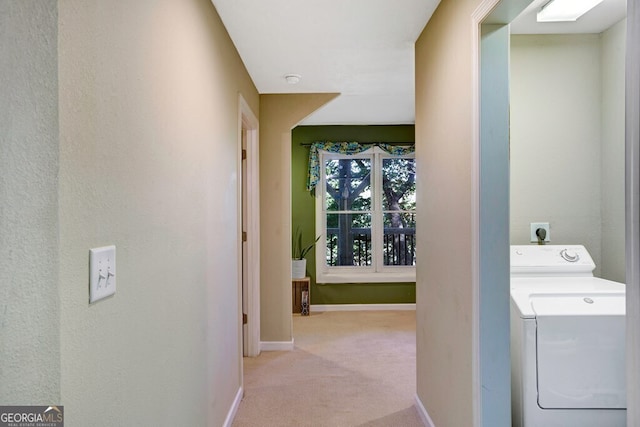 hall featuring light colored carpet and washer / clothes dryer