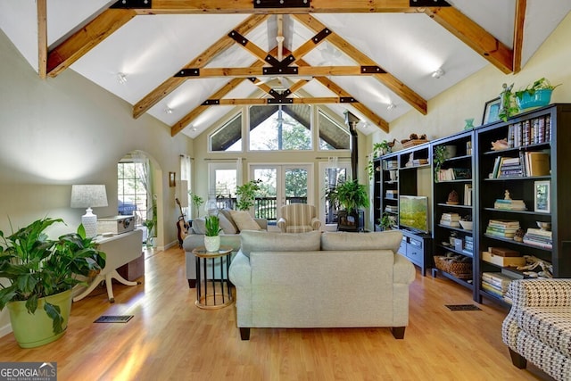 living room featuring french doors, beamed ceiling, light hardwood / wood-style flooring, and high vaulted ceiling