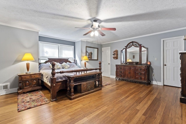 bedroom featuring a textured ceiling, hardwood / wood-style flooring, ceiling fan, and crown molding