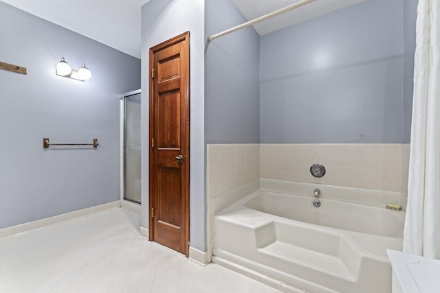 bathroom with a tub and a textured ceiling