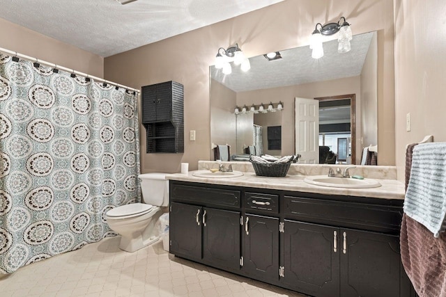 bathroom featuring vanity, a textured ceiling, and toilet