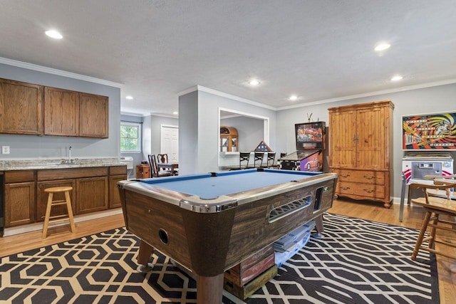 recreation room with light wood-type flooring, indoor wet bar, crown molding, and pool table