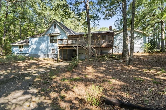 back of house with a sunroom and a deck