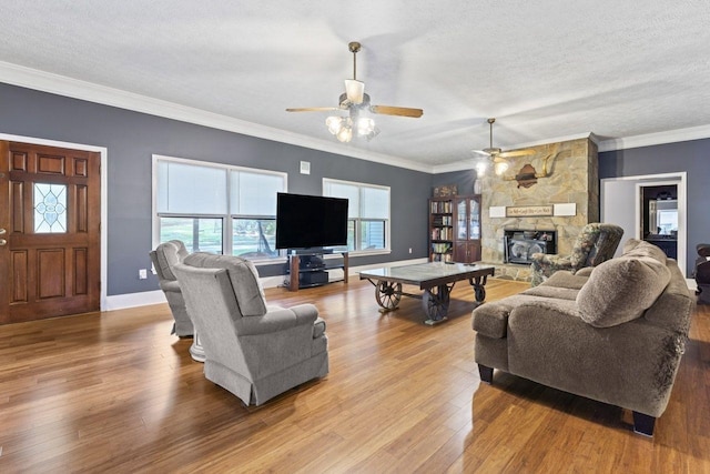 living room with a textured ceiling, light hardwood / wood-style floors, crown molding, and a fireplace