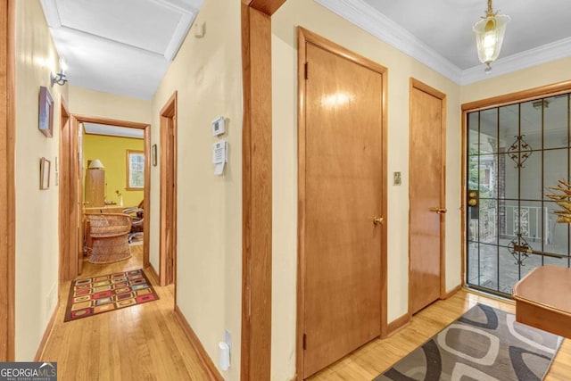 corridor with light hardwood / wood-style flooring and crown molding