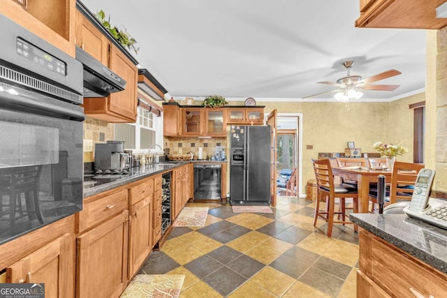 kitchen featuring sink, black appliances, ornamental molding, backsplash, and exhaust hood