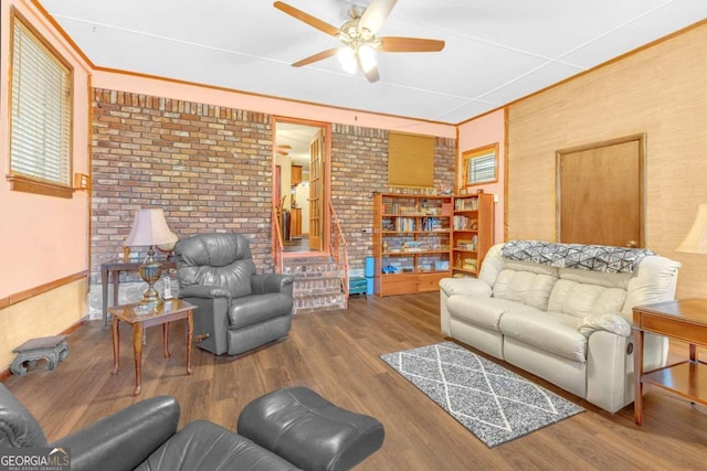 living room featuring brick wall, hardwood / wood-style flooring, and ceiling fan