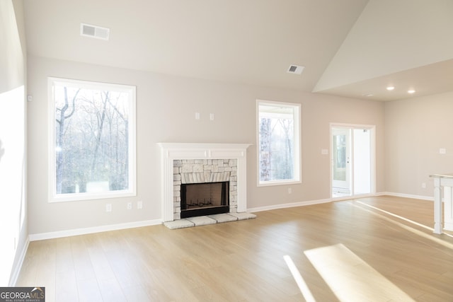 unfurnished living room with plenty of natural light, light wood-type flooring, and a fireplace