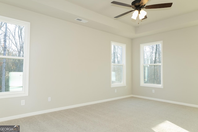 empty room with ceiling fan, carpet, and a healthy amount of sunlight