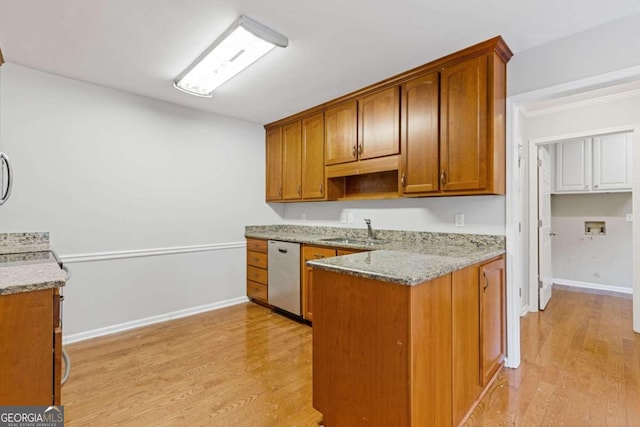 kitchen with dishwasher, light hardwood / wood-style flooring, sink, and light stone counters