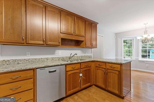 kitchen featuring dishwasher, light wood-type flooring, a chandelier, and sink