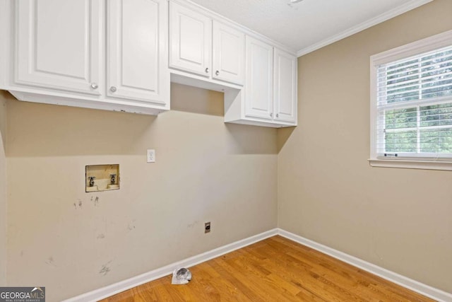 laundry area with ornamental molding, washer hookup, cabinets, and light hardwood / wood-style floors