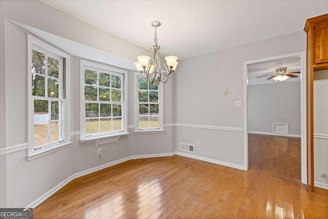 unfurnished dining area featuring light hardwood / wood-style floors and ceiling fan with notable chandelier