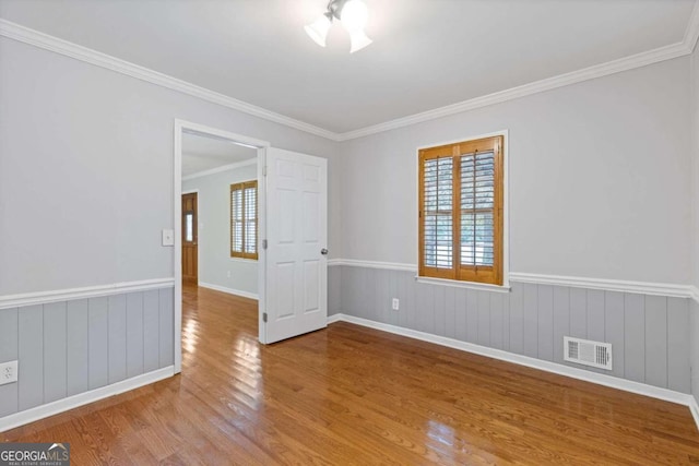 unfurnished room with light hardwood / wood-style flooring, a healthy amount of sunlight, and crown molding