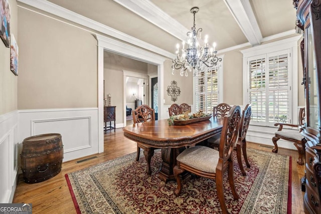 dining area featuring light hardwood / wood-style floors, an inviting chandelier, and ornamental molding