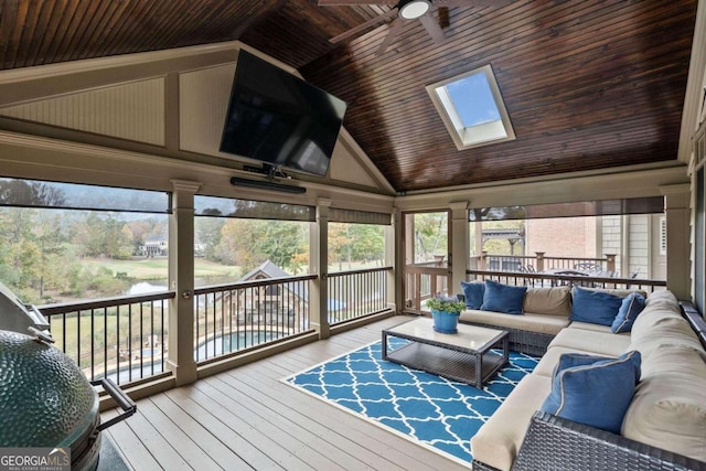 sunroom featuring vaulted ceiling with skylight