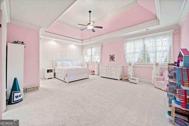 carpeted bedroom with ornamental molding, a tray ceiling, and ceiling fan