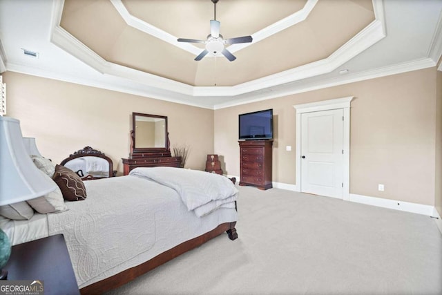 bedroom featuring a tray ceiling, multiple windows, ceiling fan, and crown molding