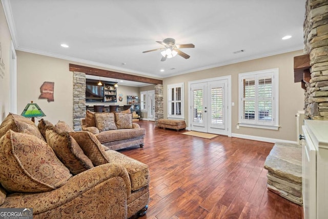 living room featuring ornamental molding, ceiling fan, dark hardwood / wood-style floors, and a fireplace