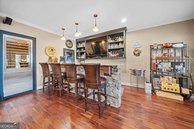 bar with hanging light fixtures, dark hardwood / wood-style floors, french doors, and ornamental molding