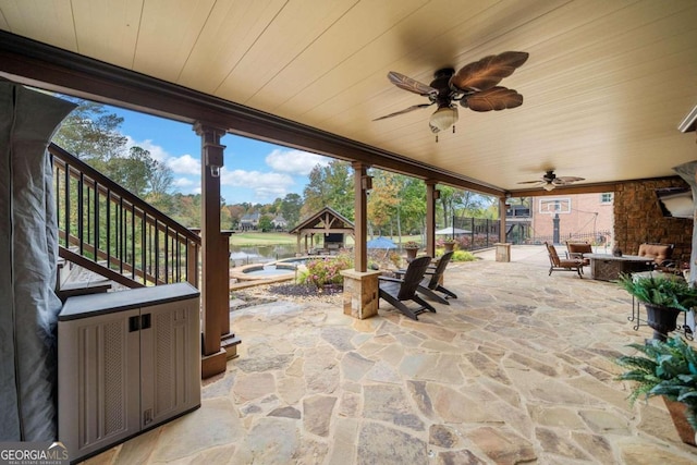 back of house with a sunroom, a balcony, pool water feature, a patio, and a pool with hot tub