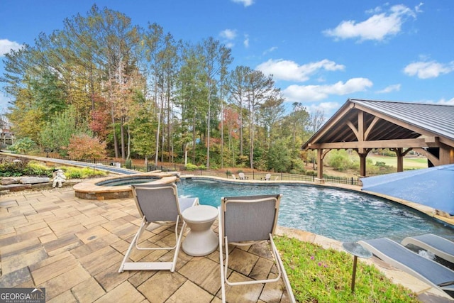 view of swimming pool featuring exterior bar, a gazebo, pool water feature, and a patio area