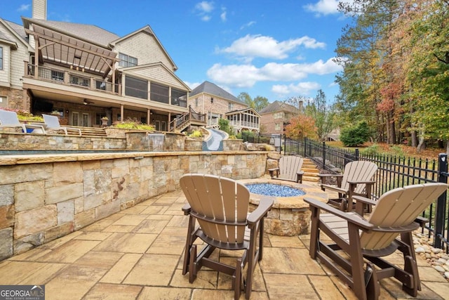 rear view of house with an outdoor hangout area, a patio area, a sunroom, a deck with water view, and a yard