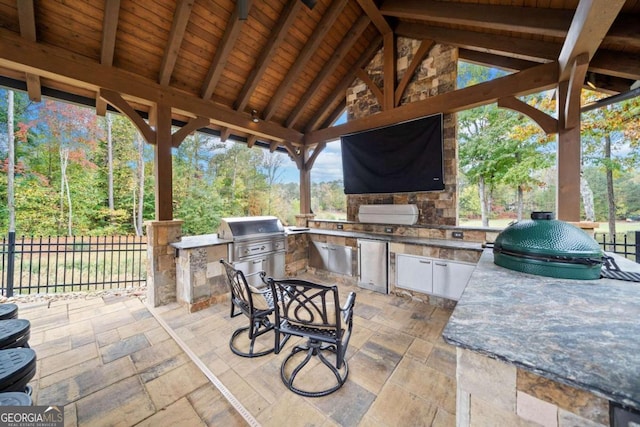 view of patio featuring exterior bar, an outdoor kitchen, and grilling area