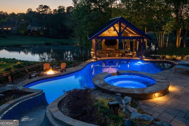 pool at night featuring a gazebo and a patio area