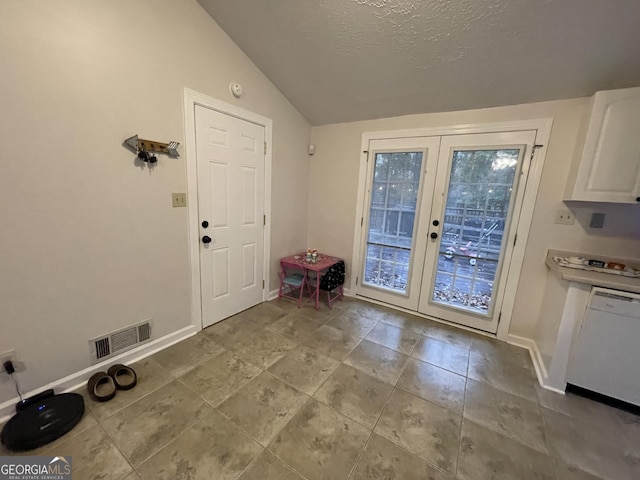 doorway featuring french doors, a textured ceiling, and vaulted ceiling