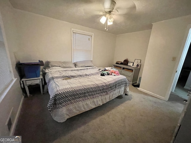 bedroom with ceiling fan, carpet, and a textured ceiling