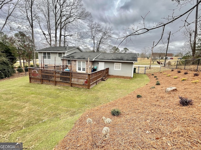 rear view of house featuring a lawn and a wooden deck