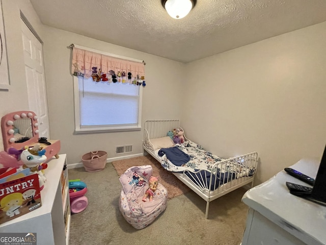 bedroom featuring carpet flooring and a textured ceiling