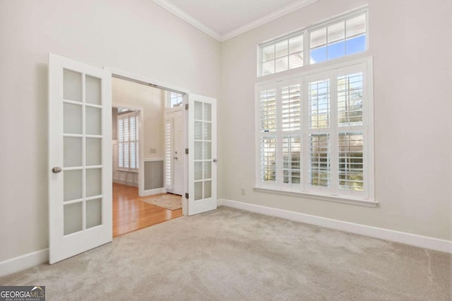 unfurnished room with ornamental molding, plenty of natural light, french doors, and carpet