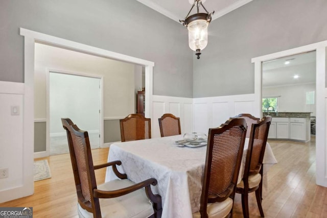 dining space featuring light hardwood / wood-style floors and crown molding