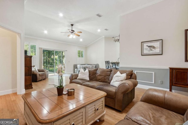 living room featuring ceiling fan, crown molding, light wood-type flooring, and vaulted ceiling