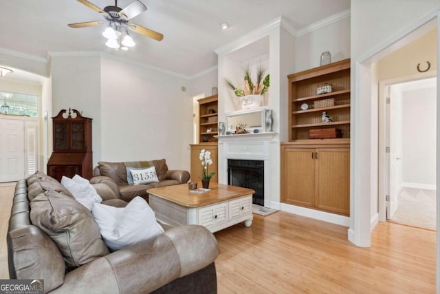 living room with light wood-type flooring, ceiling fan, and ornamental molding