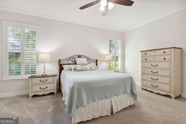 carpeted bedroom featuring ceiling fan and crown molding