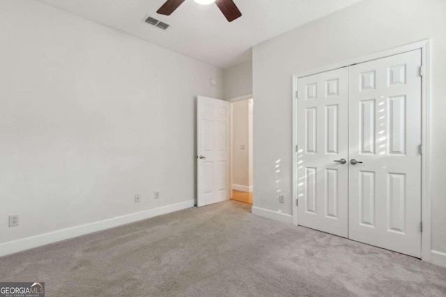 unfurnished bedroom with light colored carpet, ceiling fan, and a closet