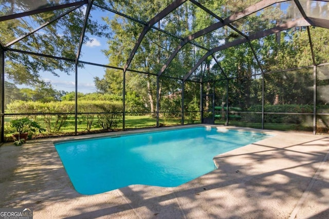 view of swimming pool featuring glass enclosure and a patio area