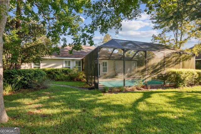 rear view of property featuring a yard and a lanai