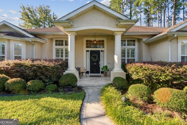 view of exterior entry featuring a lawn