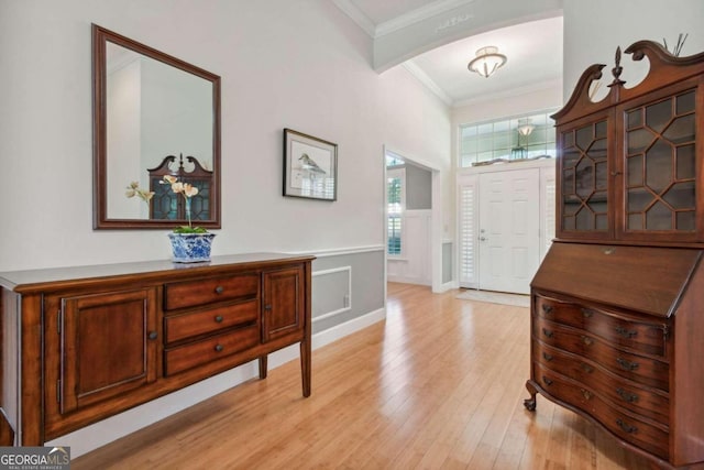 foyer with light hardwood / wood-style flooring and ornamental molding