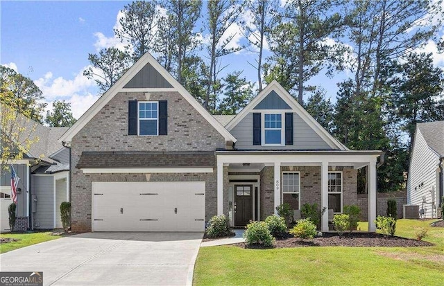 craftsman house featuring central air condition unit, a garage, and a front lawn