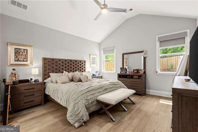 bedroom with light wood-type flooring, multiple windows, ceiling fan, and vaulted ceiling