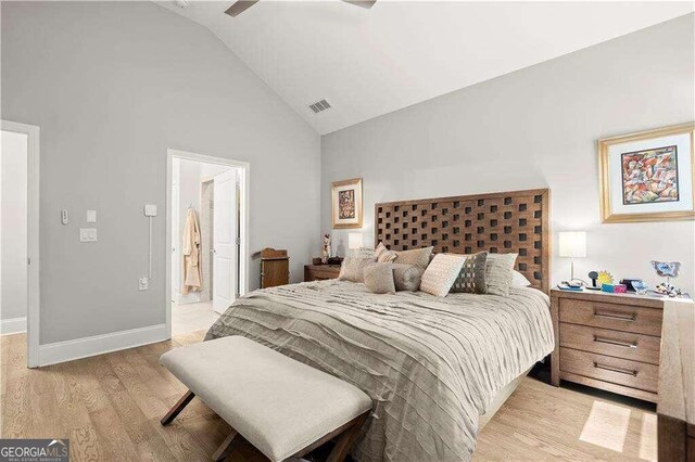 bedroom with light hardwood / wood-style floors, ceiling fan, ensuite bath, and high vaulted ceiling